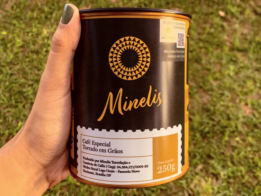 Lata Minelis segurada na mão em área verde